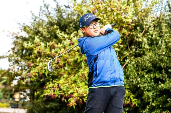 A boy practising his golf swing at Leeds Golf Centre